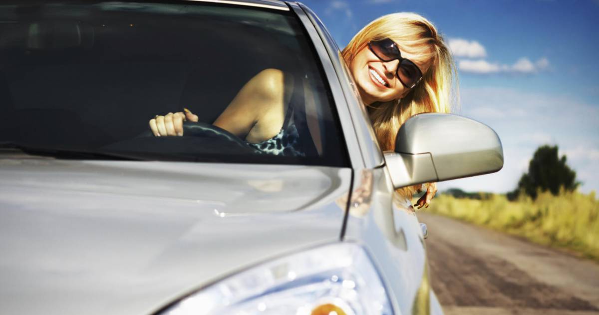 blonde vrouw met zonnebril rijd met hoofd buiten het raam