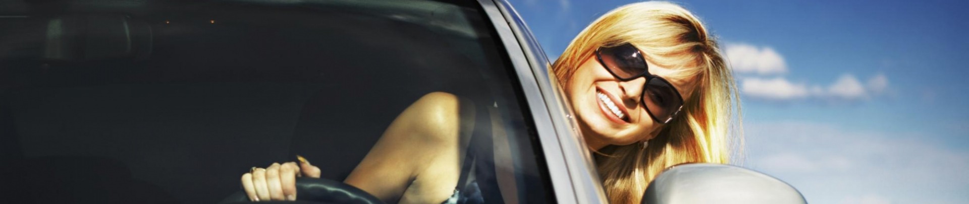 blonde vrouw met zonnebril rijd met hoofd buiten het raam